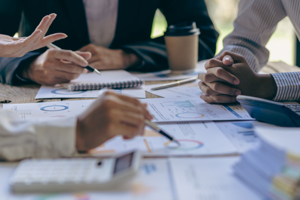 business people look at paperwork at a table, discussing options