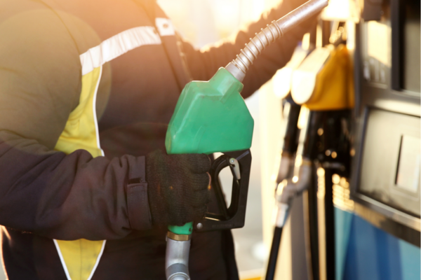 Photo of man holing green fuel pump dispenser