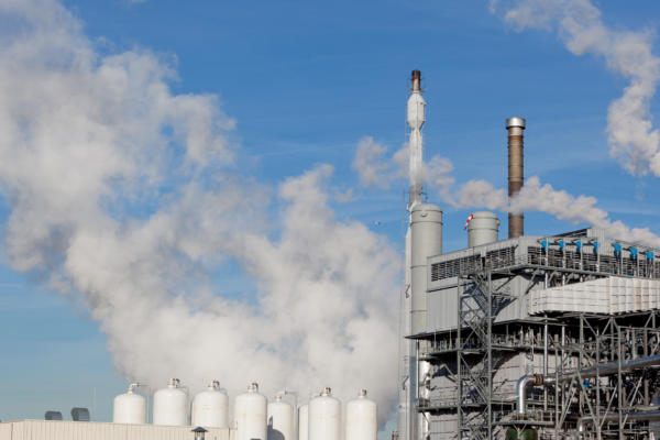 Photo of a renewable energy plant with smoke and pipes